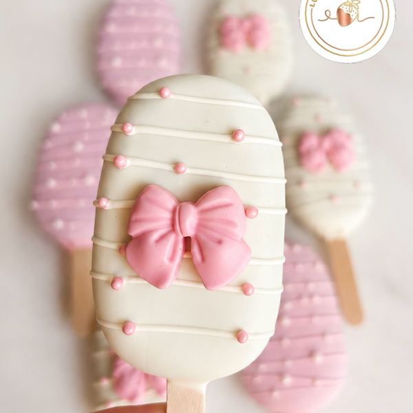 Close-up of a cakesicle with a pink sugar bow