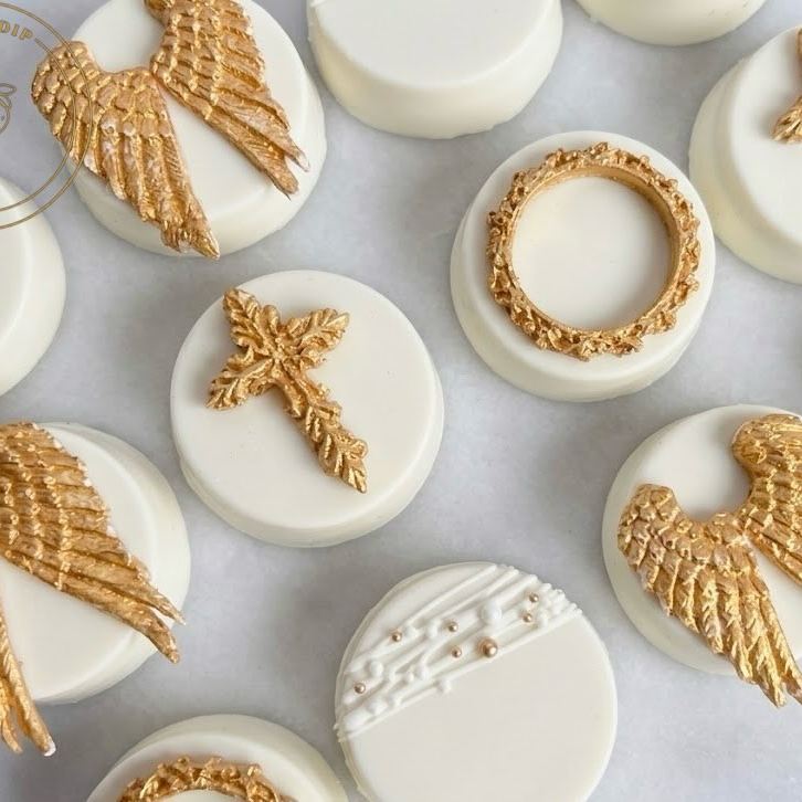 White dipped Oreos with gold angel wings and crosses