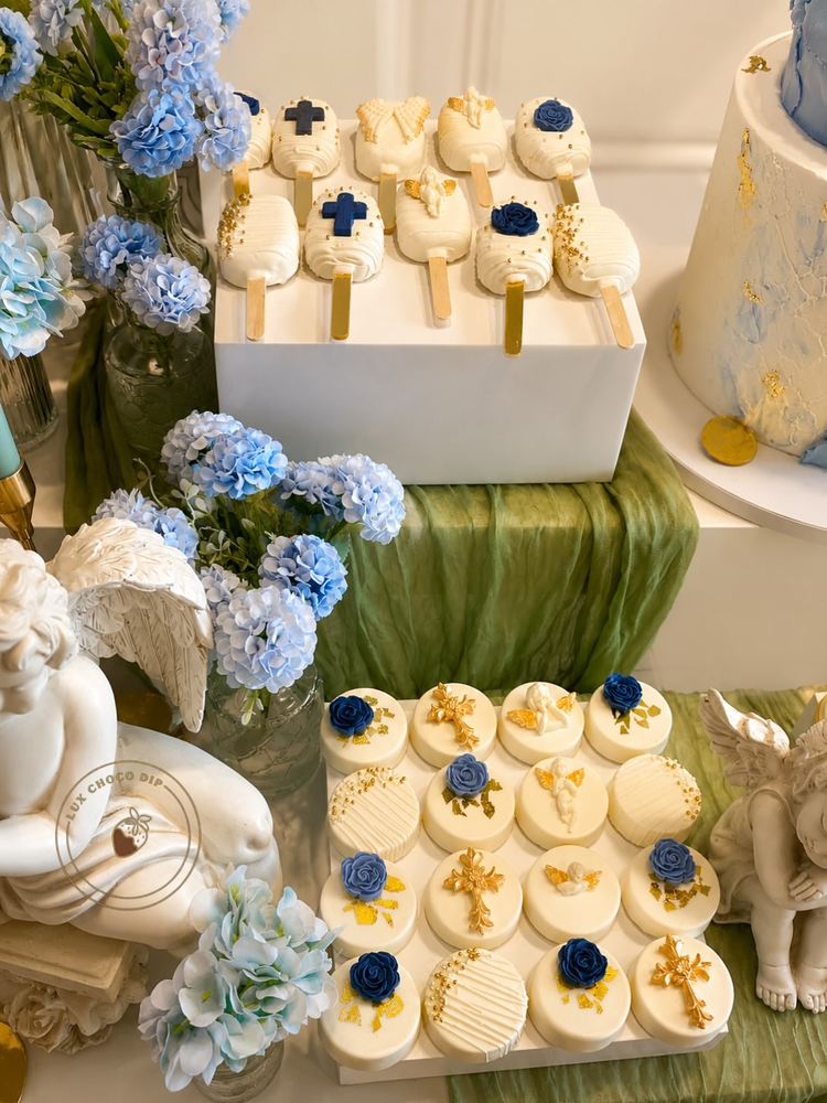 Communion sweet table with cakesicles and dipped Oreos in white, blue and gold